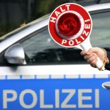 Anhaltestab vor einem Polizeiwagen